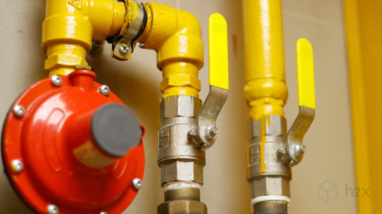 How to Size Natural Gas and LPG Pipework Yellow natural gas pipework with ball valves and a red pressure regulator, illustrating a typical gas pipe installation requiring correct pipe sizing